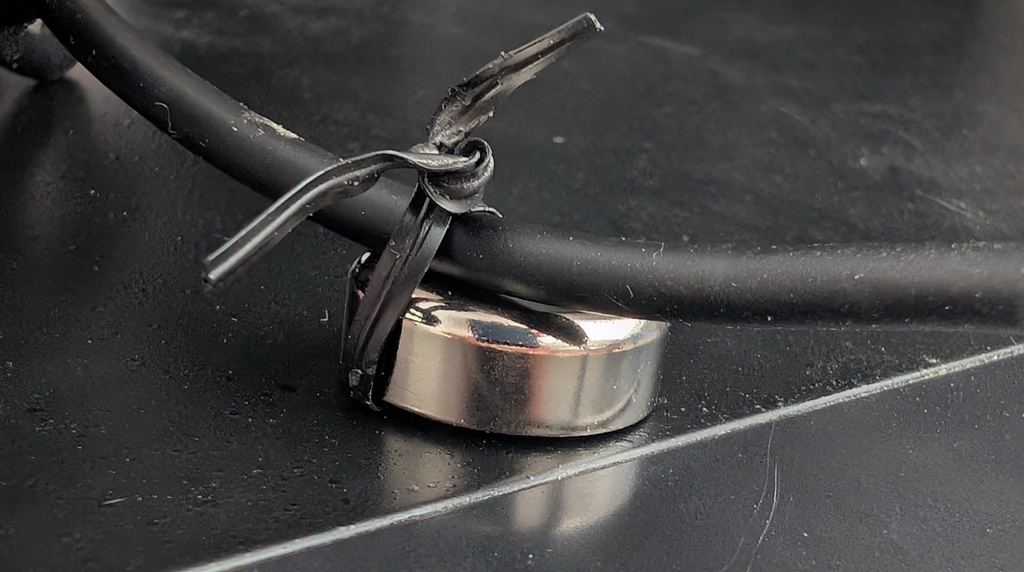 A cable held by a ring magnet and a small tie